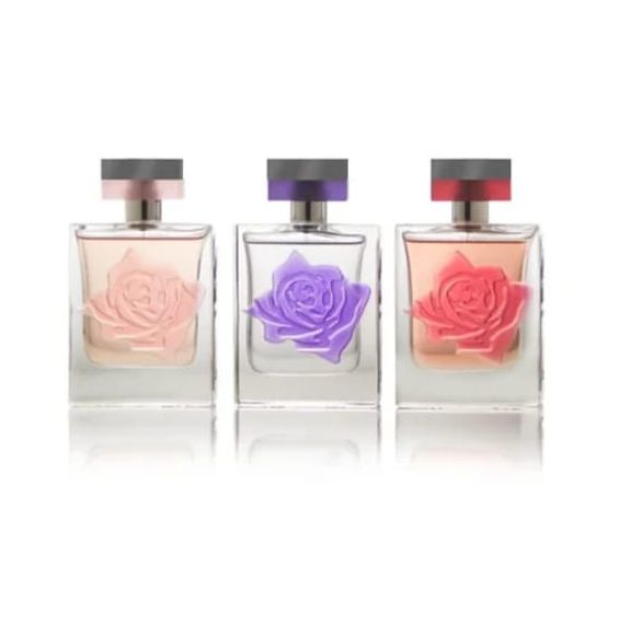 Three perfume bottles with roses on them, adding a touch of elegance and beauty to the fragrance.